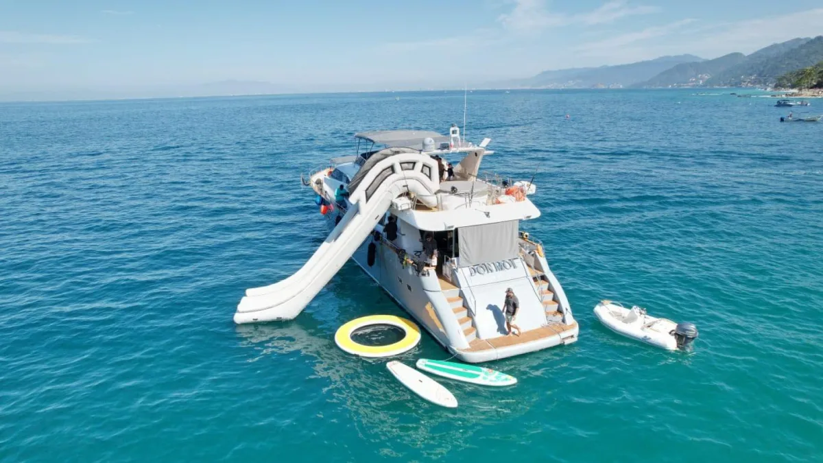 Invitados bajando por el tobogán del yate Azimut de 85 pies fondeado frente a Puerto Vallarta